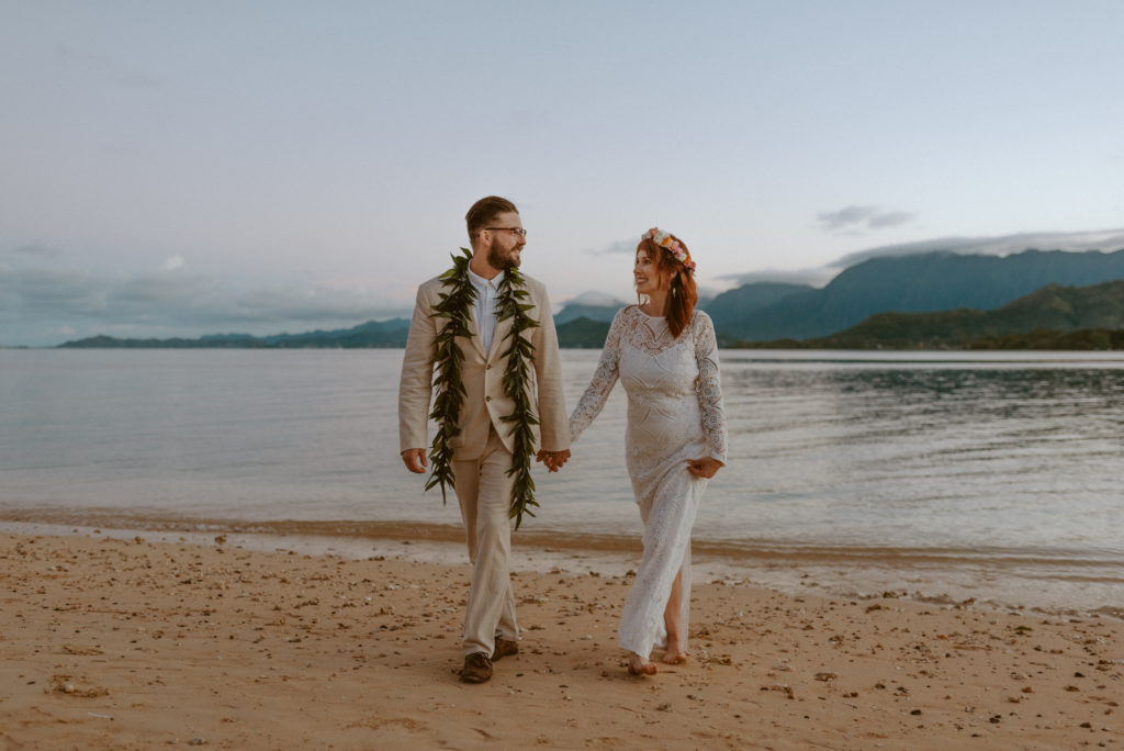 A couple walking on the beach in Oahu after their elopement in Hawaii 