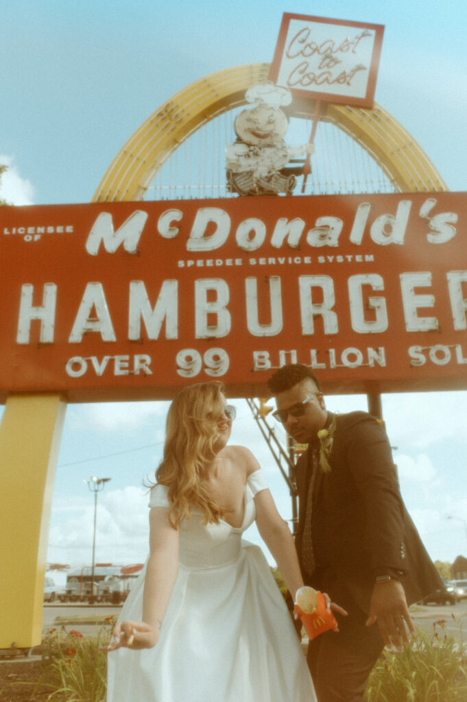 Fun unconventional wedding photo in front of an old Mcdonalds sign