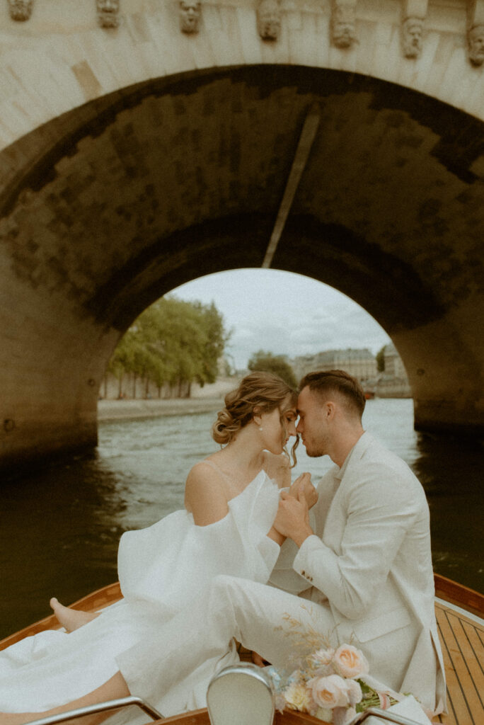 A couple takes a romantic cruise ride on the The river Seine after their paris elopement 