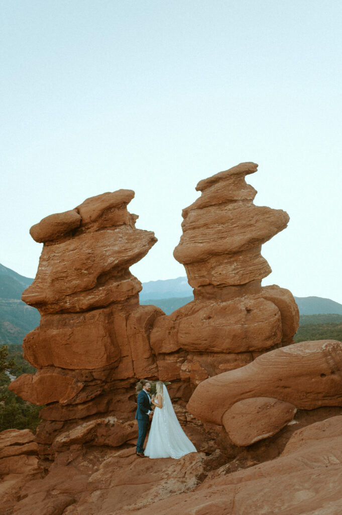 a couple having an intimate elopement at siamese twins rock formation in garden of the gods in colorado siamese twins elopement