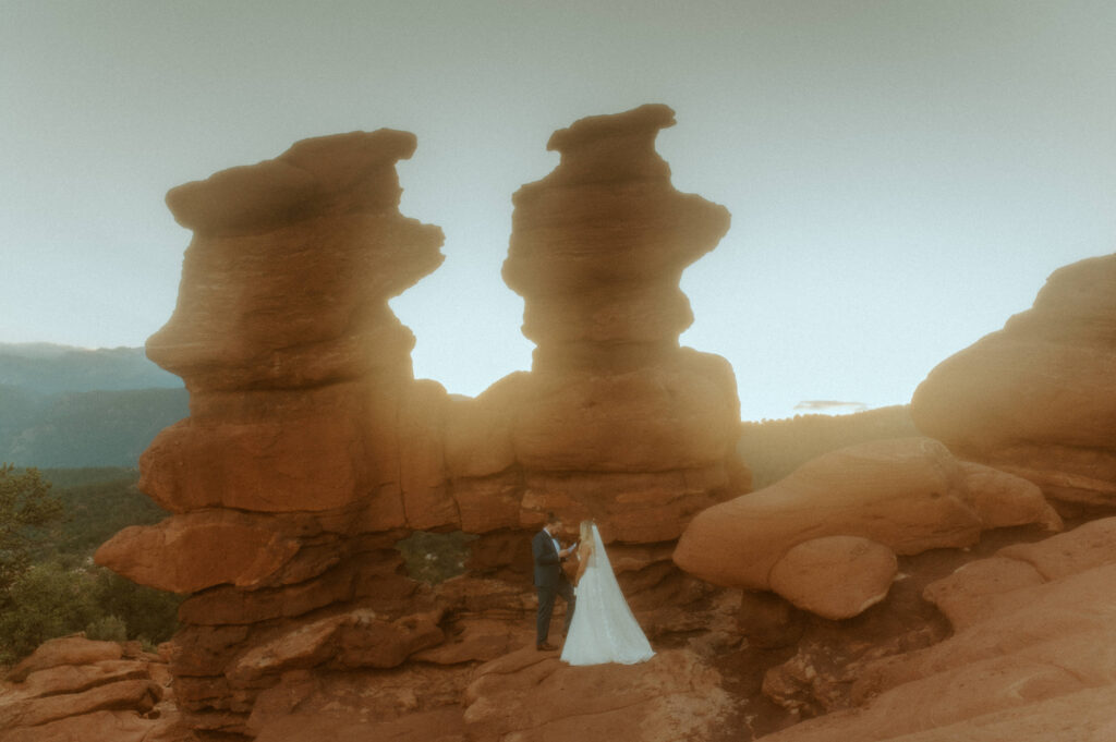 bride and groom eloping with the scenic siamese twin rock formation in garden of the gods in colorado springs siamese twins elopement