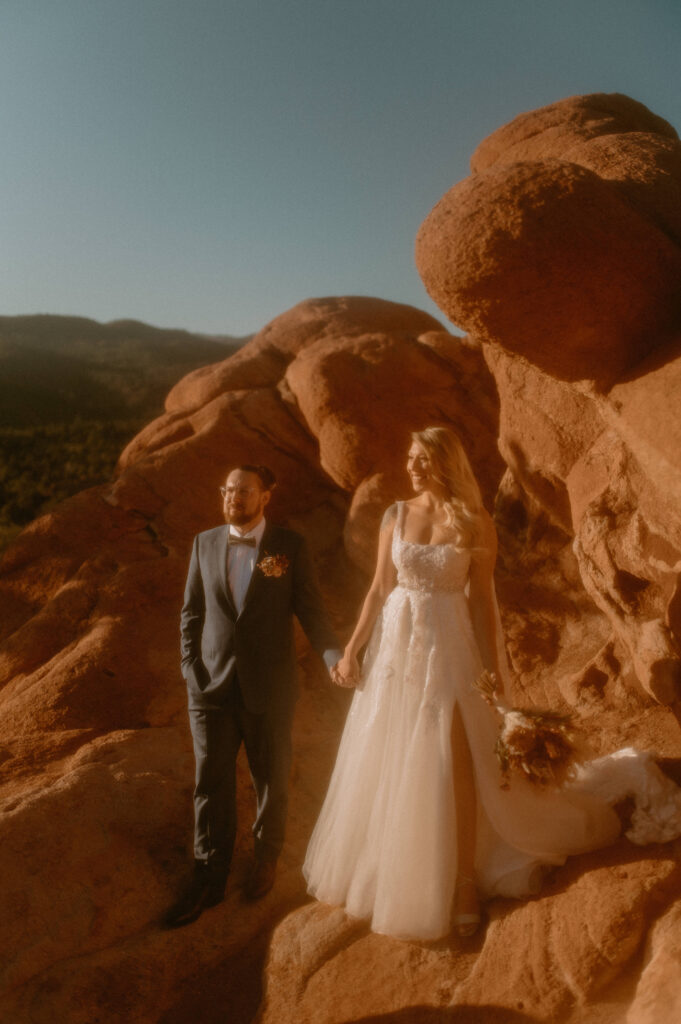 an intimate adventuous elopement happening in garden of the gods with red rocks and a bridal gown